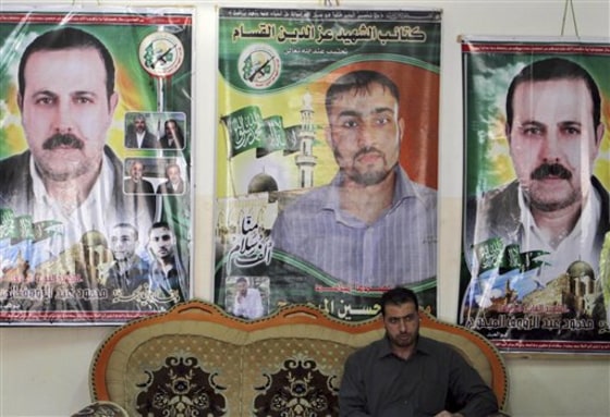 Palestinian Fayeq al-Mabhouh sits in front of posters of his brother and Hamas commander, Mahmoud al-Mabhouh, left and right, who was assassinated in Dubai, and Hamas member Mohammed Hussein Mabhouh.